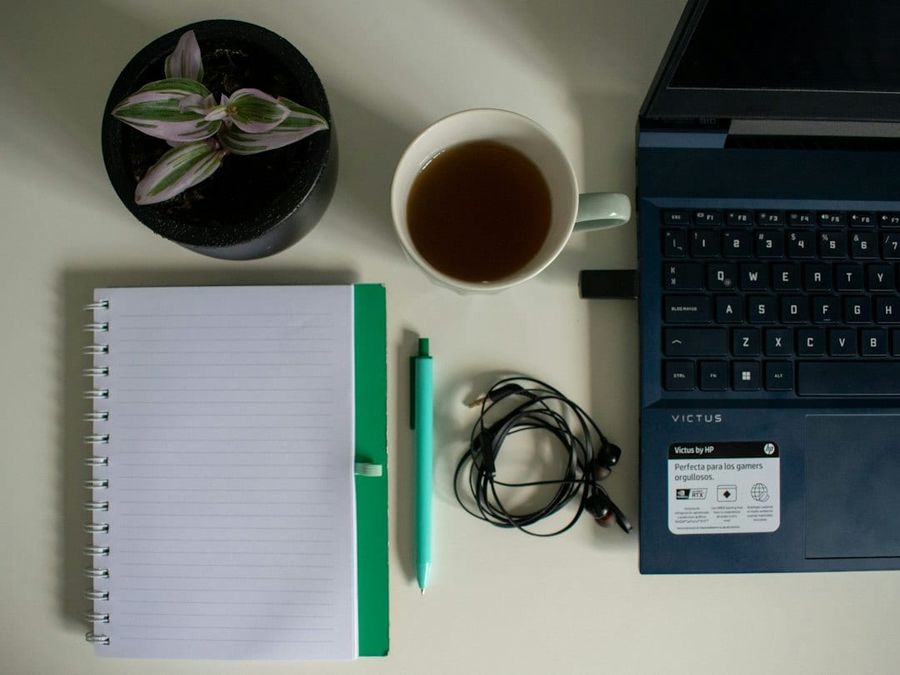Editorial desk scene with notebook, coffee and plant for property research